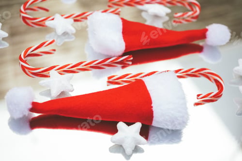 Preview: Reflected image of christmas classic decorations with candy canes, santas hat and white stars