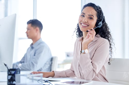 Preview: Shot of a young call centre agent sitting with her colleague and using her computer