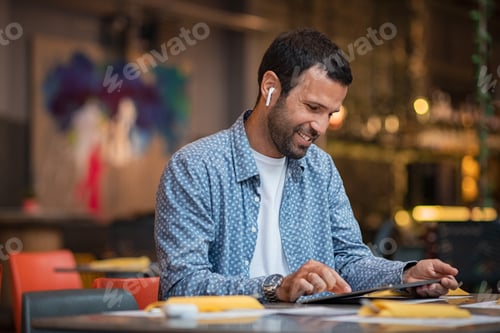 Preview: Young business man working on digital tablet