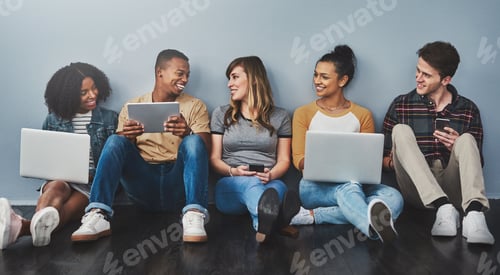 Preview: Studio shot of a group of young people using wireless technology against a gray background