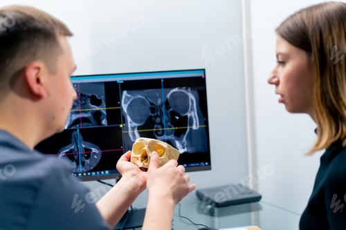 Preview: the radiologist doctor looks at the screen on which the 3D image of the nose scan shows the patient