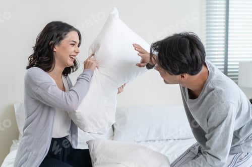 Preview: Asian young beautiful loving couple have pillow fight together on bed.
