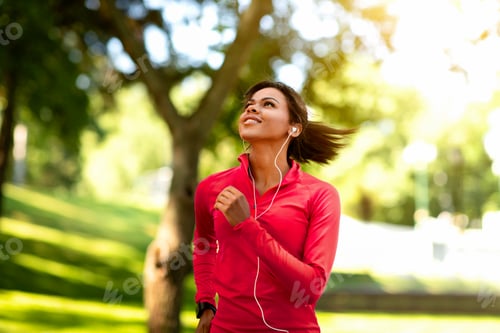 Preview: Joyful black girl jogging by summer park