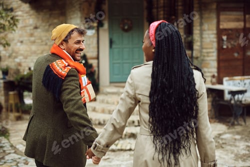 Preview: Young happy man carrying presents while going party with his black girlfriend during Christmas day,