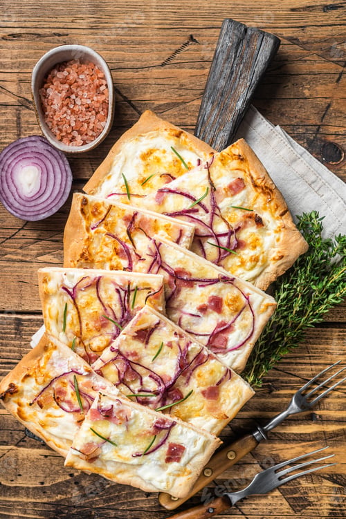 Preview: Flammkuchen or tarte flambee with cream cheese, bacon and onions. Wooden background. Top view