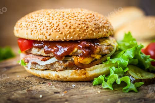 Preview: Homemade hamburger. Bun with sesame seeds. Cooking a burger. Food on the table