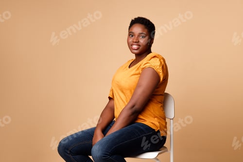 Preview: Smiling Woman Sitting on a Chair Posing