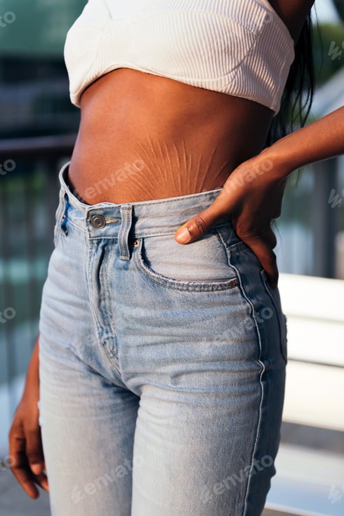 Vista previa: detail of the flat belly of a young african woman