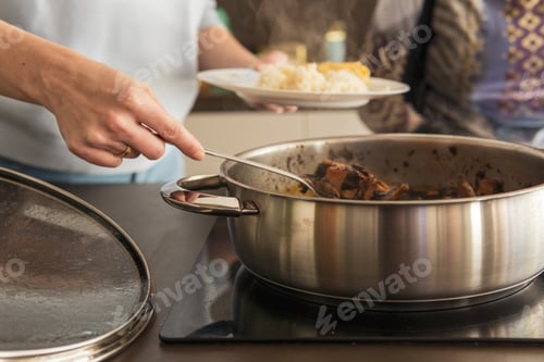 Preview: Close up of mother and senior grandmother serving food in the kitchen