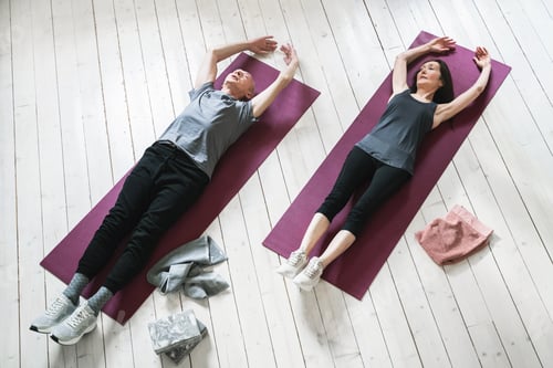 Preview: Active elderly people working out on the exercise mats at home