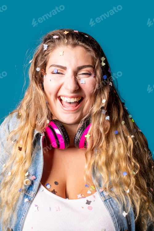 Preview: Black female celebrating having fun spreading confetti on blue background