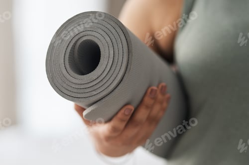Preview: Woman Holding a Rolled Up Grey Yoga Mat