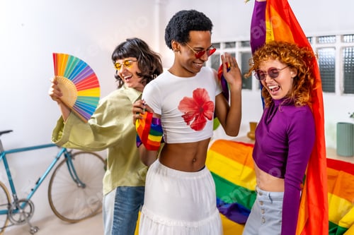 Preview: Multi-ethnic and gender diverse friends celebrating pride party at home