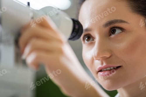 Preview: young oculist tuning ophthalmoscope on blurred foreground
