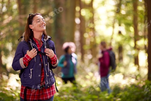 Preview: Woman Closing Eyes Enjoying Peace As Group Of Female Friends On Holiday Hike Through Woods Together