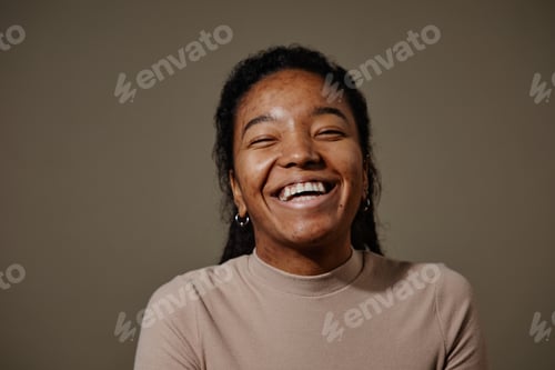Preview: Candid black young woman laughing neutral beige background in studio