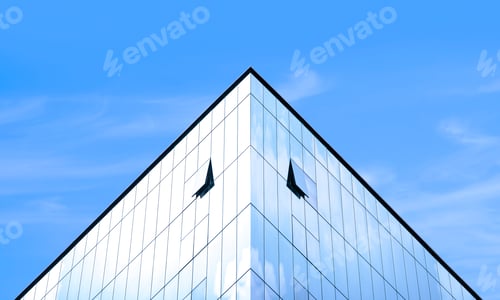 Preview: Light reflection on modern glass office building against blue sky in symmetry and low angle view