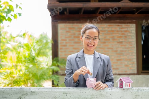Preview: Asian businesswomen hold piggy banks and put coins in piggy banks to save money with coins to step