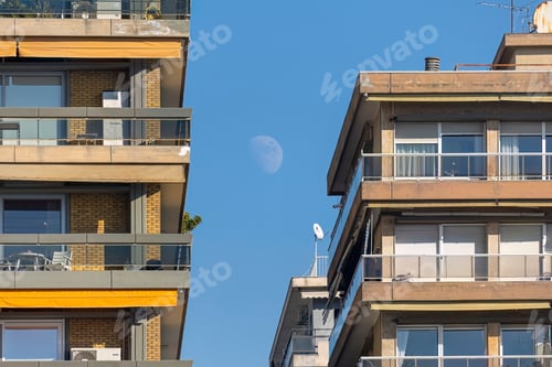 Preview: Scenic view of two residential buildings next to each other under a blue sky.
