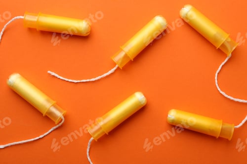 Preview: Women tampons on orange background, top view