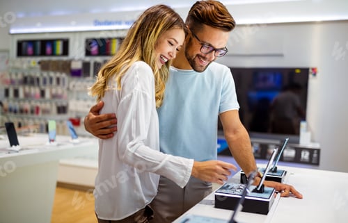 Preview: Tech shopping device gadget concept. Happy young people buying a new smartphone in mobile shop.