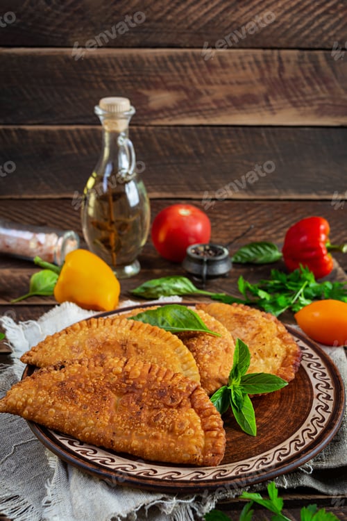 Preview: Traditional Crimean Tatar cuisine, chebureki with chicken meat. Fried empanadas on wooden background