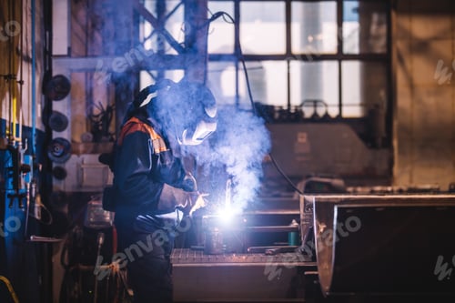 Preview: Worker welding in oxygen mask in a factory