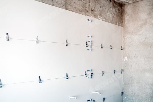 Vista previa: obra de construcción.azulejos modernos en el baño con separador y nivelación durante las obras.renovación