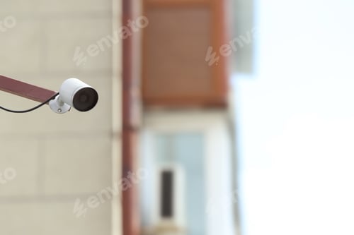 Preview: Modern CCTV security camera on building wall outdoors. Space for text