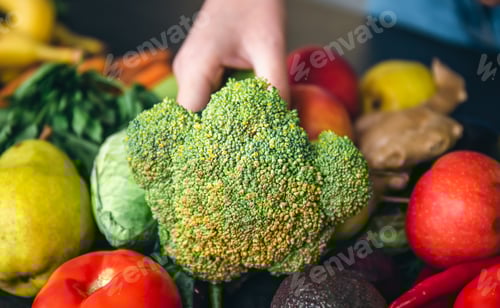 Preview: Close-up, cabbage in a woman's hand on the kitchen table among vegetables.