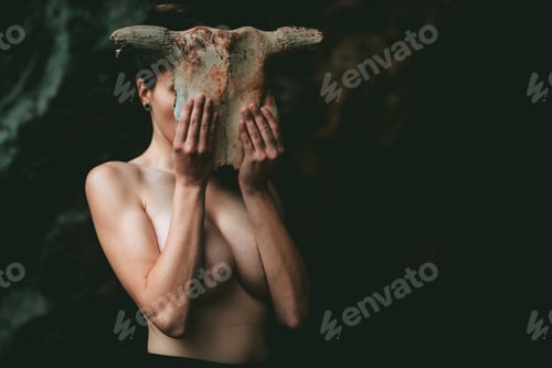 Preview: Topless woman covering face with spooky skull