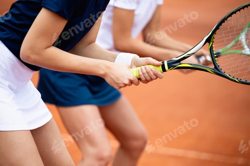 Preview: Young happy fit women playing tennis on tennis court