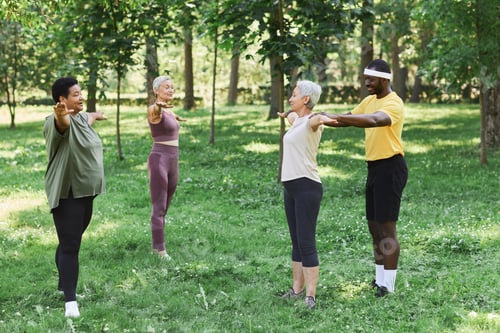 Preview: Three senior women working out outdoors in park with trainer assisting