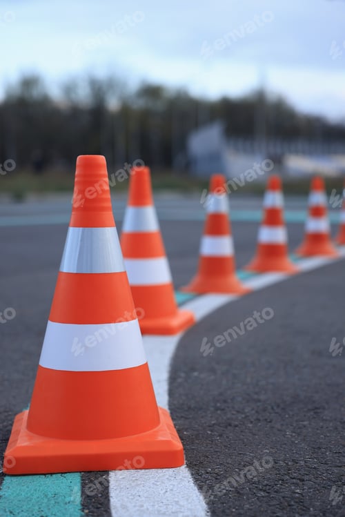 Preview: Driving school test track with marking lines, focus on traffic cone