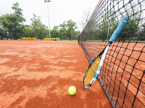 Preview: Tennis racquet and tennis ball on clay court