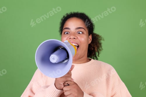 Preview: Beautiful african american woman on green background screaming shouting in megaphone ask attention