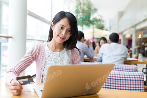 Preview: Woman use credit card to pay the bill on laptop computer