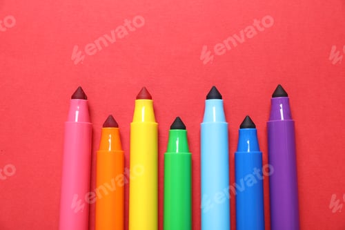 Preview: Many colorful markers on red background, flat lay