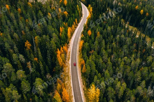 Preview: Aerial view of autumn color forest in the mountains and a road with car in Finland Lapland.