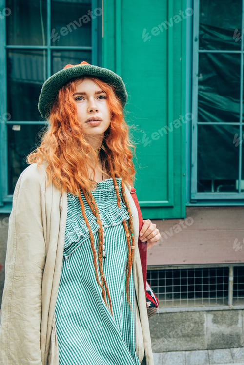 Preview: Beautiful red-haired woman walking on the street.