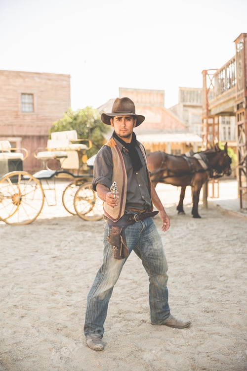Preview: Portrait of cowboy pointing gun on wild west film set, Fort Bravo, Tabernas, Almeria, Spain