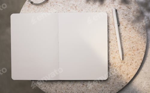 Preview: open blank notebook with pen on stone table with sunlight