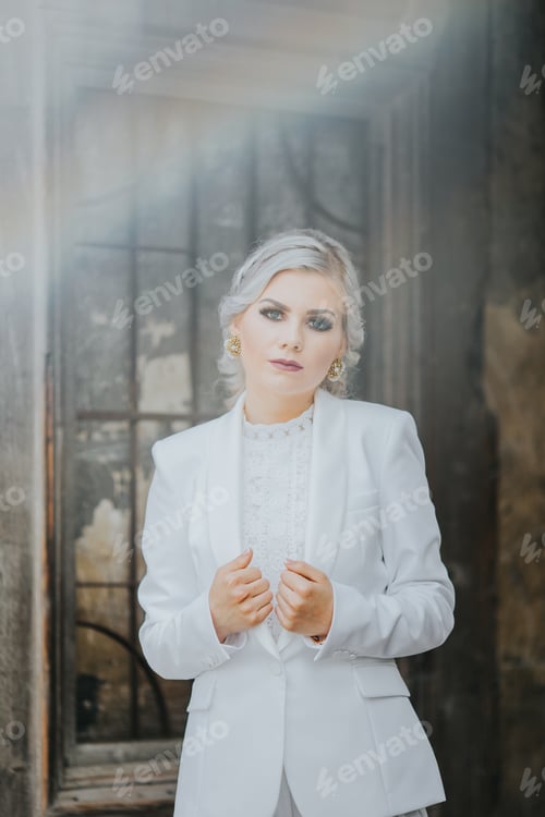 Preview: Elegant fashionable Caucasian female in a pretty white suit and pants posing for fashion photoshoot