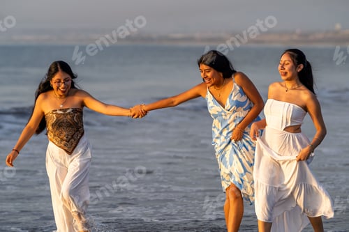 Preview: Happy young women friends enjoying beach sunset