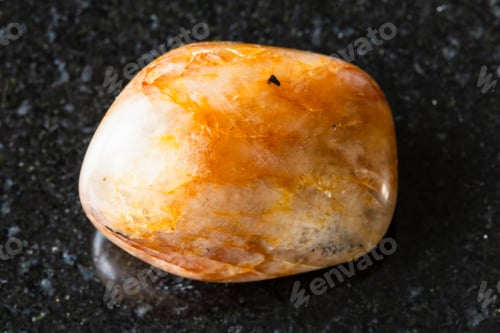Preview: sample of tumbled orange quartz mineral on black