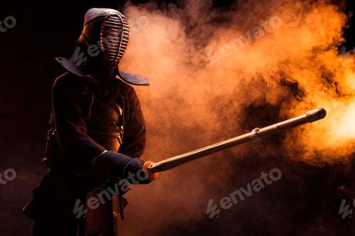 Preview: Kendo fighter in armor practicing with bamboo sword in smoke