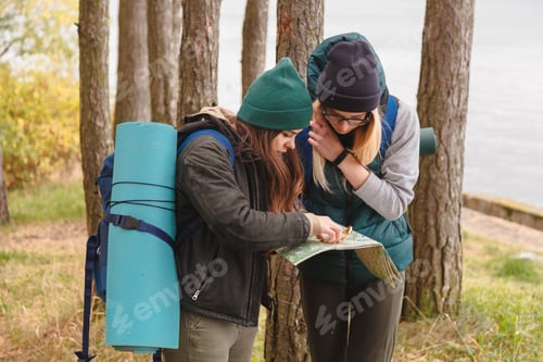 Preview: Two young tourist determine the route map and compass