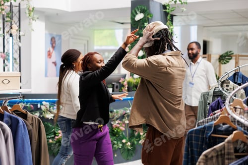 Visualização: Amigos estilosos experimentando chapéu, se divertindo na loja.