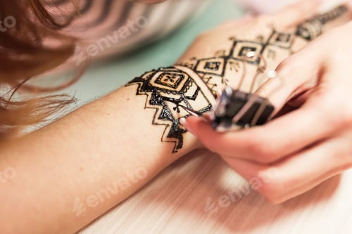 Preview: Drawing process of henna menhdi ornament on woman's hand.