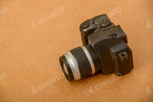 Preview: Black toy dslr camera on wooden background.